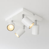 White ceiling light fixture with three adjustable lights on a white background