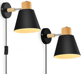Two wall-mounted lamps with black shades and wooden accents on a white background
