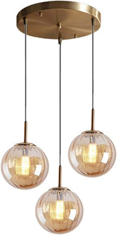 Modern pendant light fixture with three glass shades on a white background