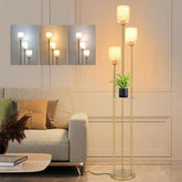 Gold floor lamp in a living room setting with a sofa and decorative pillows.