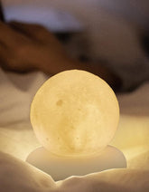 Moon-shaped night light on a soft surface with a blurred background