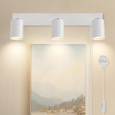 Modern wall-mounted light fixture with three cylindrical lights on a beige wall.