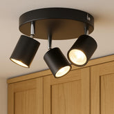 Black ceiling light fixture with three lights on a neutral background