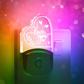 LED night light plugged into a bedroom wall socket, emitting a warm white glow