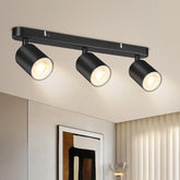 Modern black ceiling light fixture with three lights on a ceiling.