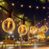 String lights with glowing bulbs in an outdoor setting at night.