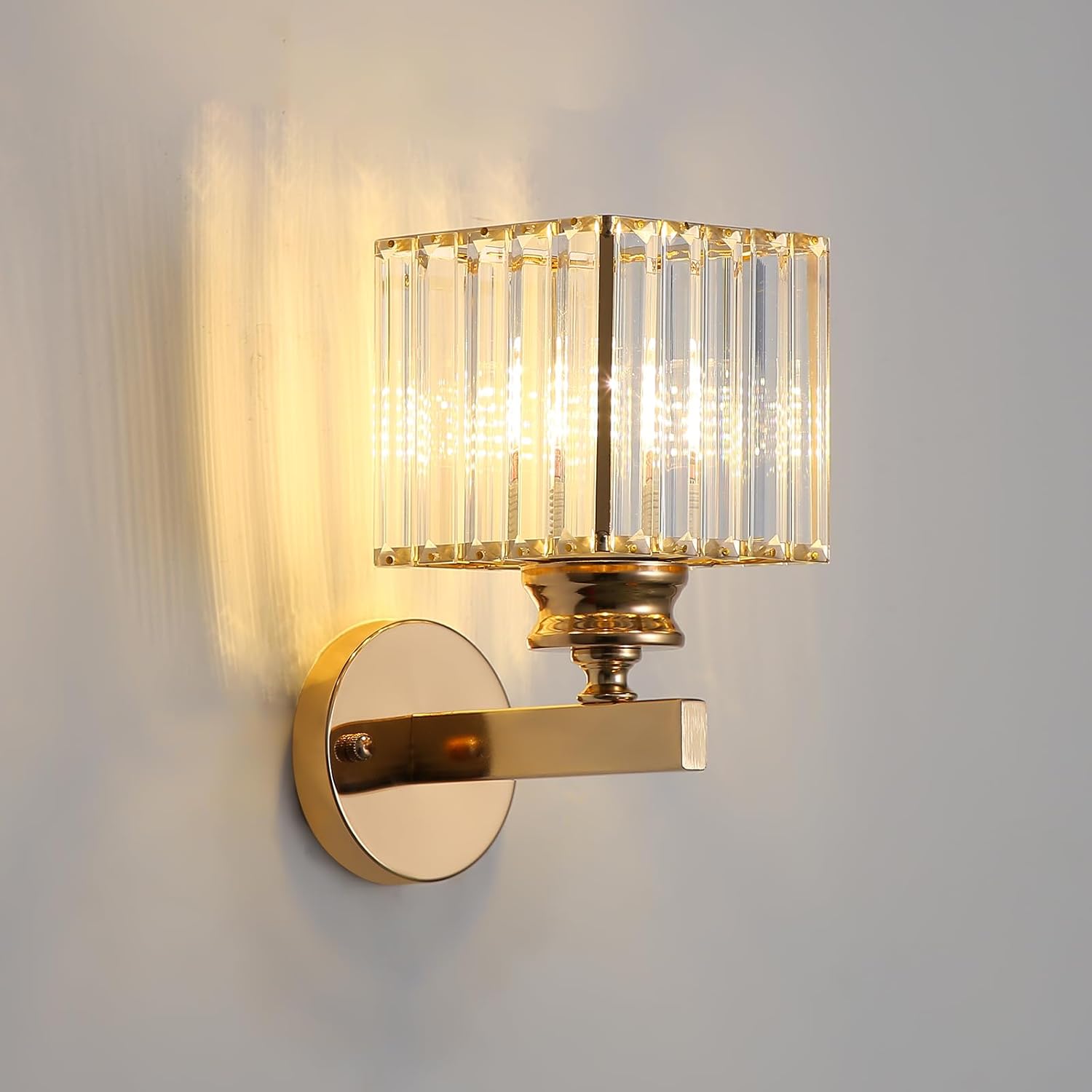 Gold wall sconce with crystal detailing on a gray background
