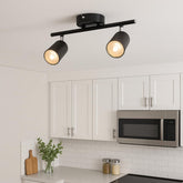Black ceiling light fixture in a kitchen with white cabinets and a microwave.