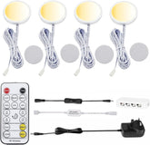 Set of LED puck lights with remote control and power adapter on a white background