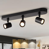 Black ceiling light fixture with three adjustable lights on a white ceiling.