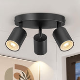 Black ceiling light fixture with three cylindrical lights on a white ceiling.