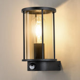 Black outdoor wall light fixture with glass cover on a neutral background