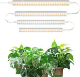 Set of LED grow lights above potted plants on a white background