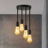 Ceiling light fixture with four lit bulbs against a gray wall.