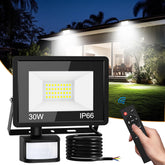 Outdoor flood light with remote control in front of a house at night.
