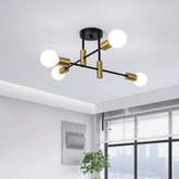 Modern ceiling light fixture with gold and black design in a room with large windows.