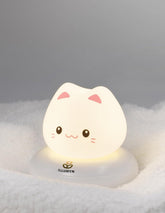 Cute cat-shaped night light on a soft surface with a gray background