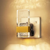 Decorative wall switch with a gold accent on a beige wall