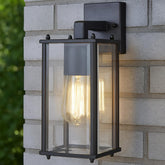 Black outdoor wall light fixture on a stone wall