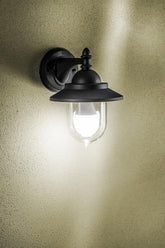 Black outdoor wall light fixture on a textured wall