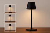 Black table lamp with a square base on a wooden surface, with inset images showing light direction.