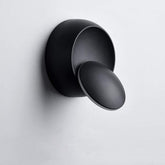 Black wall-mounted light fixture on a gray background