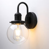 Black wall-mounted light fixture with a clear glass shade on a white background