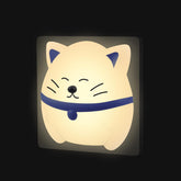 Cat-shaped night light with a blue collar on a black background