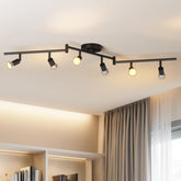 Ceiling-mounted track light fixture with multiple bulbs on a white ceiling.