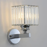Chrome wall sconce with clear glass shade on a gray background