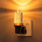 Decorative night light attached to a wall socket with a warm glow.