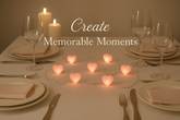 Dining table set for a romantic dinner with heart-shaped candles, wine glasses, and cutlery.