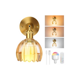 Gold wall-mounted light fixture with remote control and bulb on a white background
