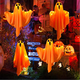 Halloween decorations with glowing orange ghosts and pumpkins in a festive setting.