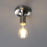 Light bulb in a metallic fixture against a plain background