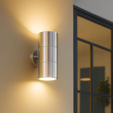 Metallic outdoor wall light fixture on a wall with a blurred background