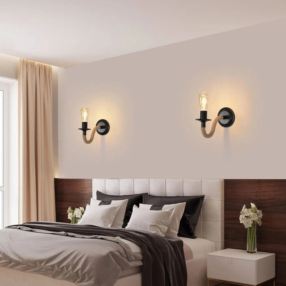 Modern bedroom with a bed, wall sconces, and decorative elements.