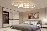 Modern bedroom with a ceiling light fixture, bed, and wall art.