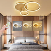 Modern bedroom with ceiling lights and a hand holding a remote control.