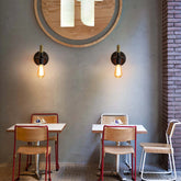 Modern cafe interior with tables, chairs, and wall lights.