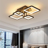Modern ceiling light fixture in a room with a window and wall.