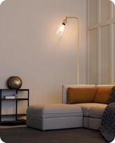 Modern living room with a gray sectional sofa, gold floor lamp, and decorative items.