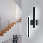 Modern wall lights on a gray wall with a staircase in the background