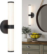 Modern wall sconce with a decorative mirror and fruit bowl in the background
