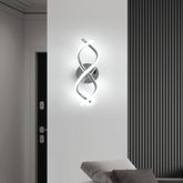 Modern wall sconce with a spiral design on a white wall.