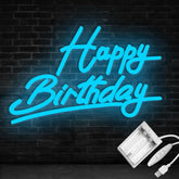 Neon sign with 'Happy Birthday' text on a brick wall background, with power adapter below.