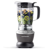 Nutribullet blender with fruits and vegetables inside on a white background