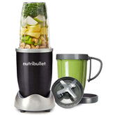 Nutribullet blender with ingredients inside and a separate green cup on a white background