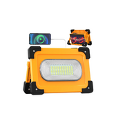 Orange work light with smartphone charging pad on a white background