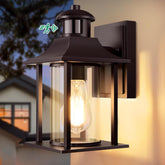 Outdoor wall light fixture on a house exterior with warm glow